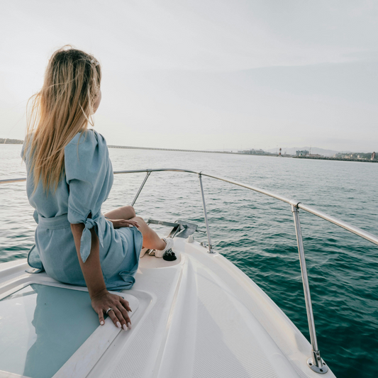 une femme sur un bateau assie regardant le large